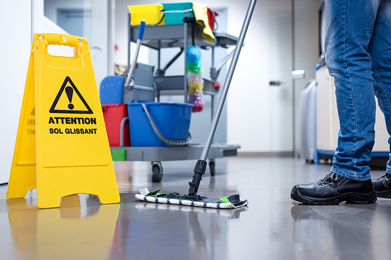 Worker janitor Mopping Floor In Office with trolley